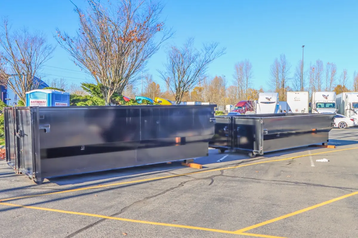 Professional dumpster rental service with roll-off container on residential driveway in International Falls